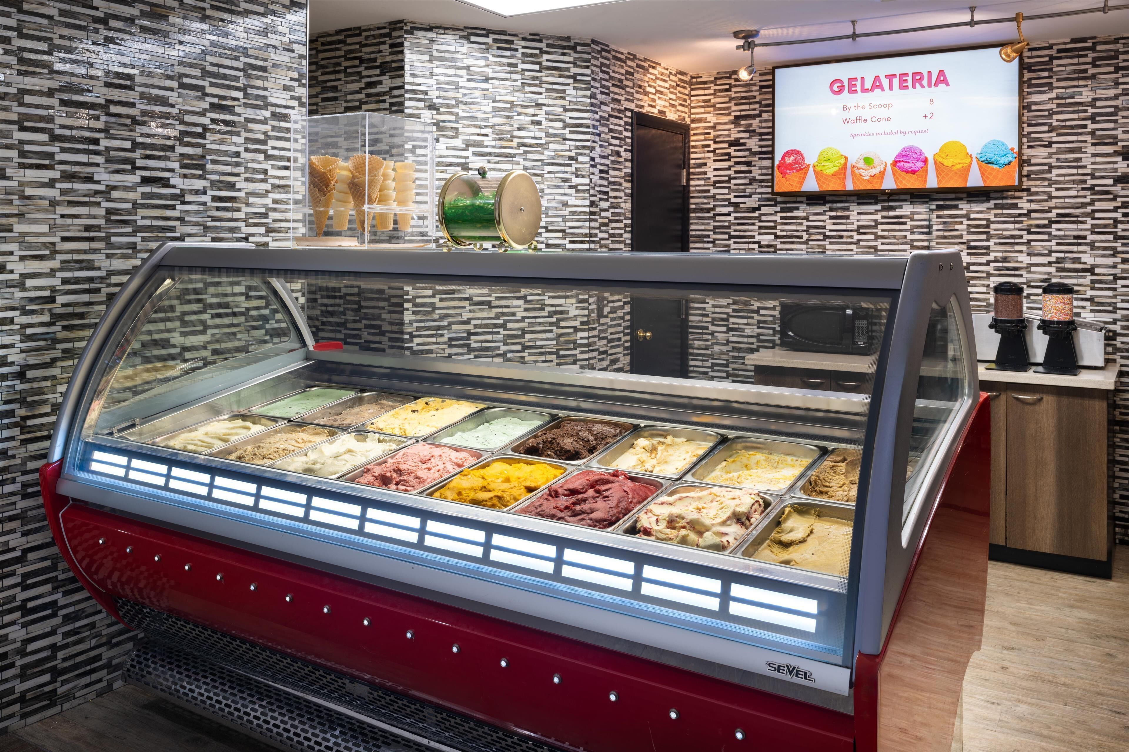 An ice cream parlor with a variety of ice cream flavors in a glass display case.