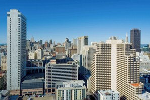 Un hotel grattacielo con diversi piani, un parcheggio sotterraneo e un assortimento di edifici moderni e più datati sullo sfondo.