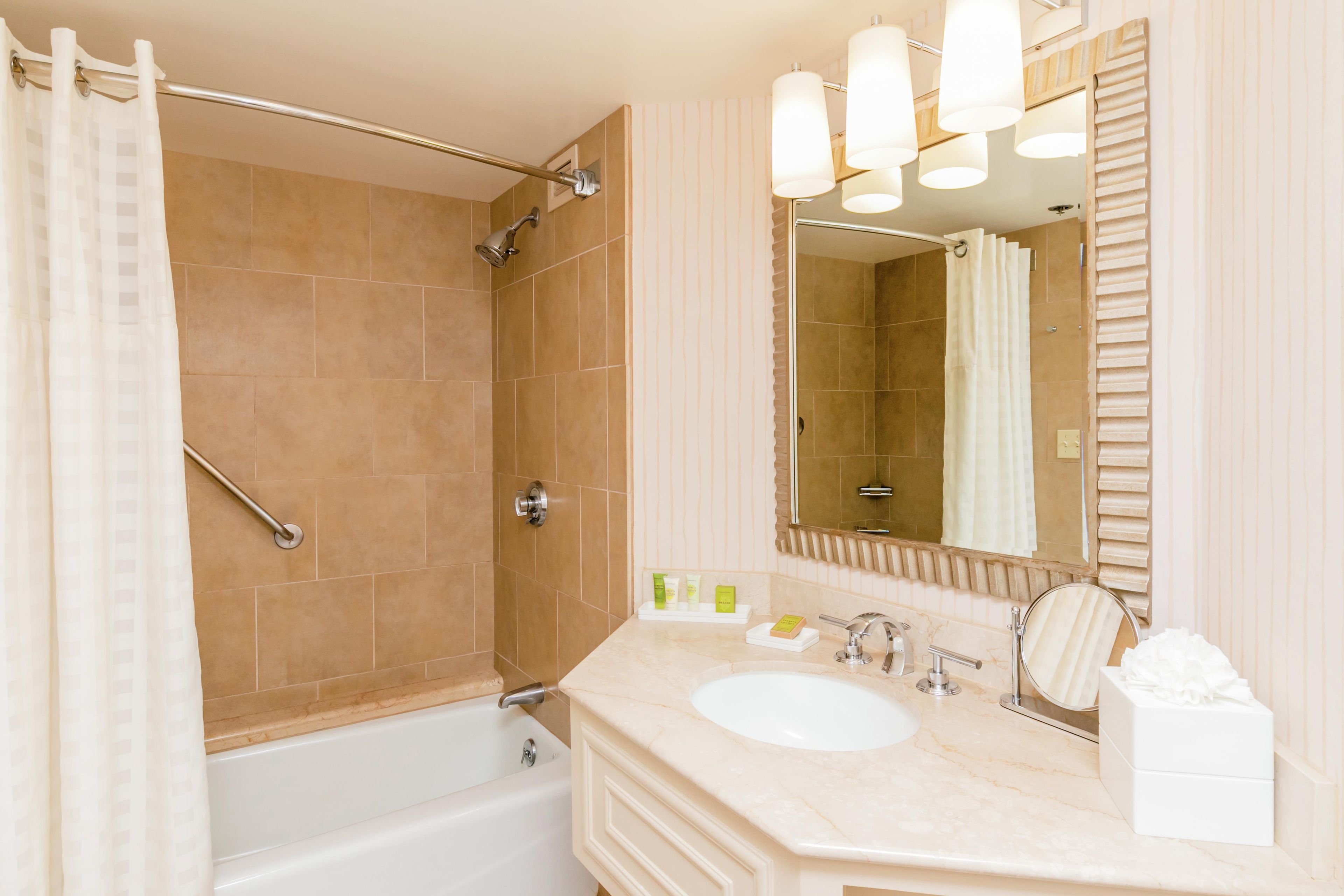 Un baño con ducha, bañera, lavabo y espejo.