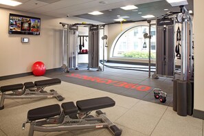 A gym with weightlifting equipment, benches, and a red exercise ball. - Parc 55 San Francisco - A Hilton Hotel (San Francisco)