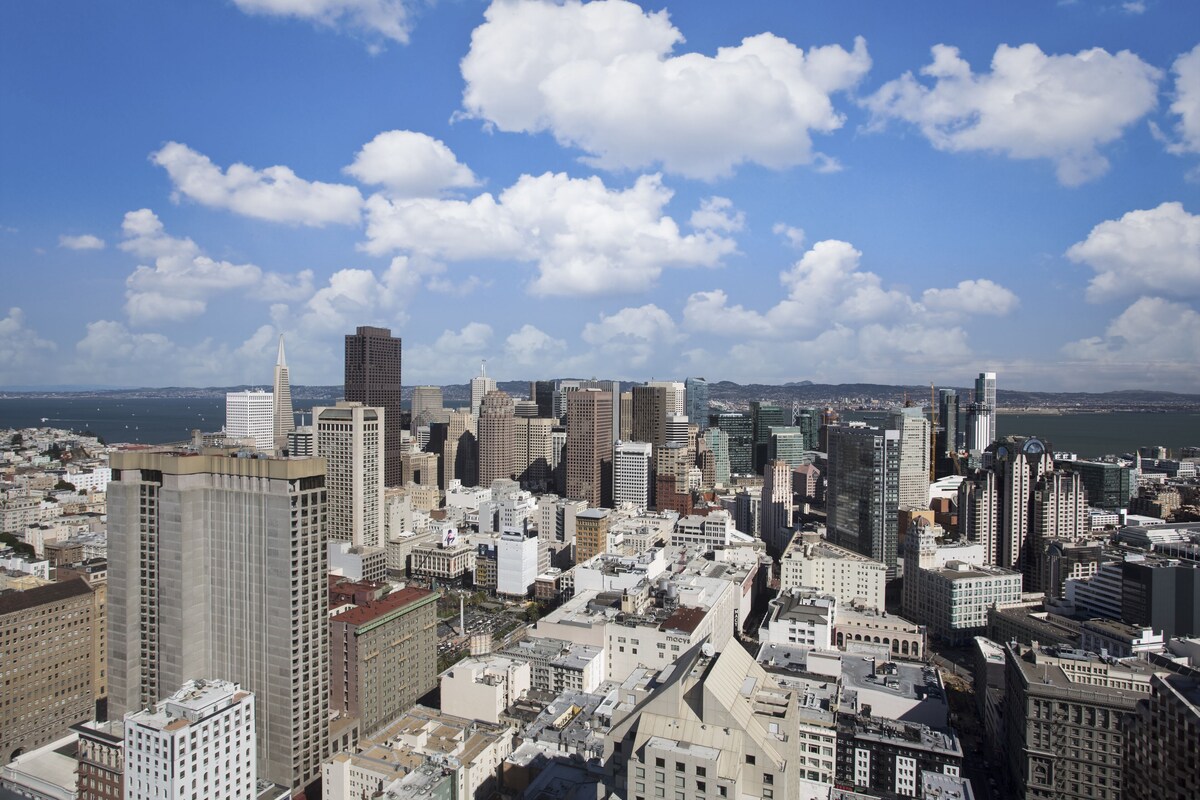 A high-rise cityscape with dense urban architecture and a clear sky.