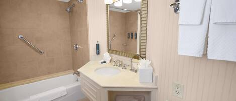A modern bathroom with a bathtub, a sink, a mirror, and a towel rack.