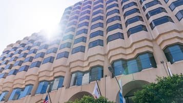 A high-rise building with a modern architectural design, featuring a series of balconies and large windows.