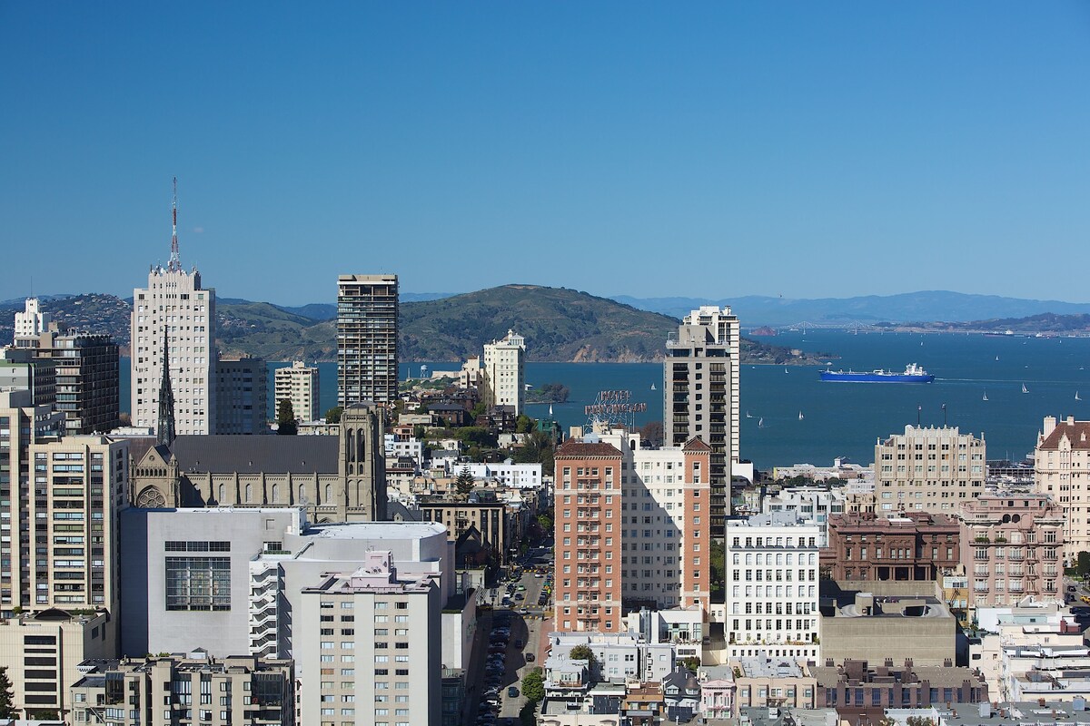 A cityscape with various buildings, including a prominent tower and several high-rise structures.