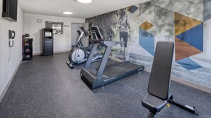 A gym with treadmills, a stationary bike, and a bench. - Best Western Greensboro Coliseum Inn (Greensboro)