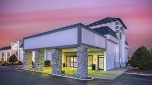 A modern hotel with a covered entrance, stone pillars, and a large window. - Best Western Greensboro Coliseum Inn (Greensboro)