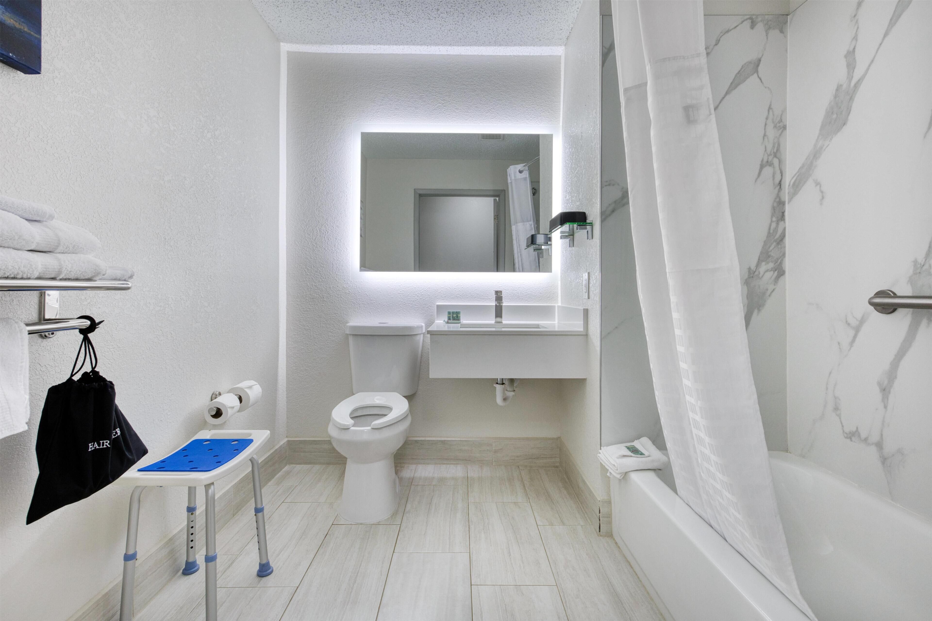 Un baño moderno con inodoro, lavamanos y ducha.