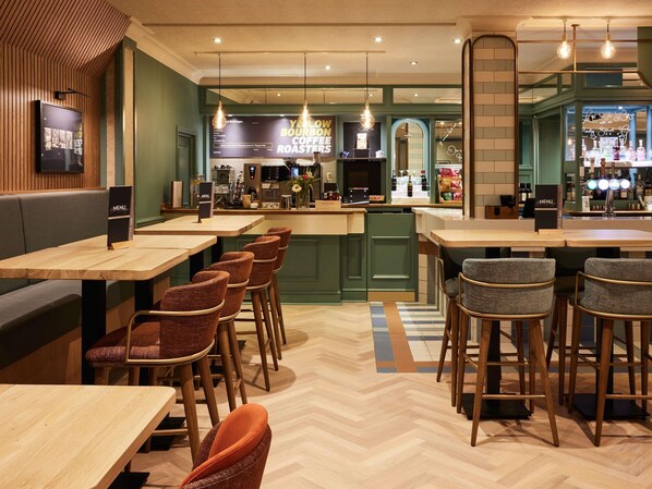 A restaurant interior with wooden tables and chairs, a bar area, and a menu stand.