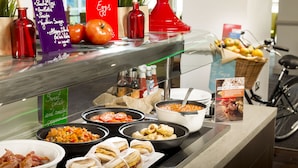 A buffet with various food options including eggs, bacon, and sandwiches.