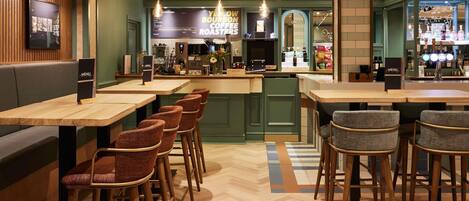 A restaurant interior with wooden tables and chairs, a bar area, and a menu stand.
