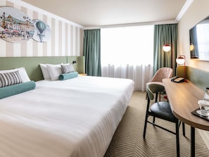 A hotel room with a large bed, a desk with a telephone, and a chair. - Mercure Northampton (Northampton)