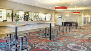 A modern bar area with stools, a counter, and a patterned carpet.