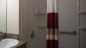 A bathroom with a white sink, a mirror, a shower curtain, and a towel rack. - Red Roof Inn Blythe (Blythe)