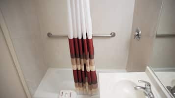 Un baño con bañera, lavamanos y baranda.