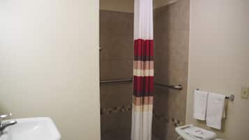 Ein Badezimmer mit Dusche, Waschbecken und Handtuchhalter.