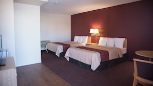 A hotel room with two beds, a small table, and a chair. - Red Roof Inn Blythe (Blythe)