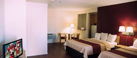 A hotel room with two beds, a desk, a chair, and a television.
