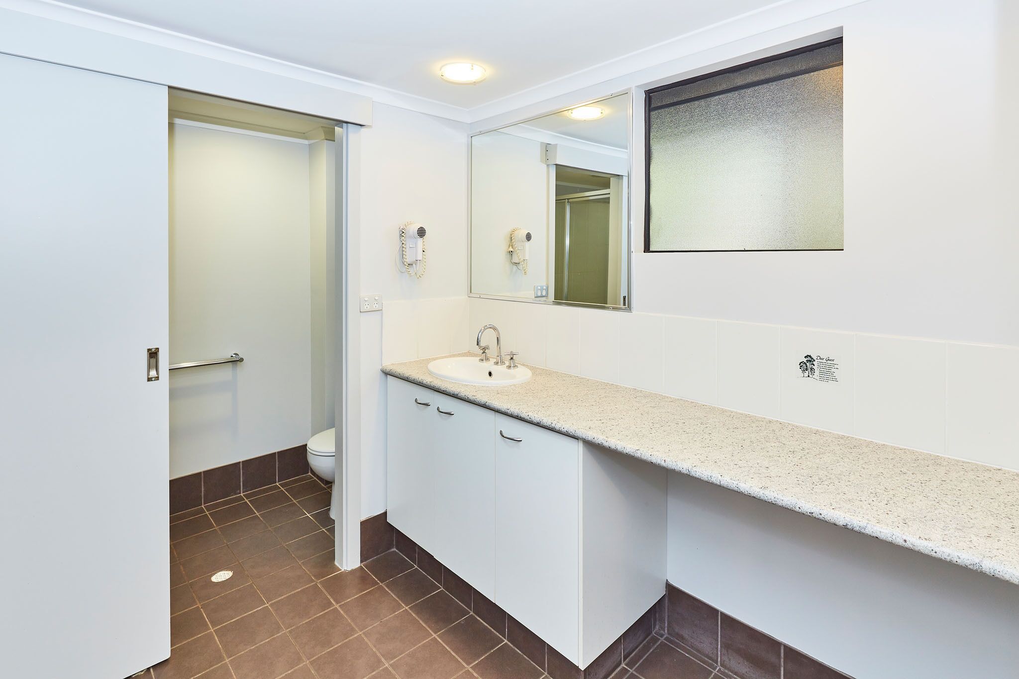 A bathroom with a white sink, a mirror, and a towel rack.