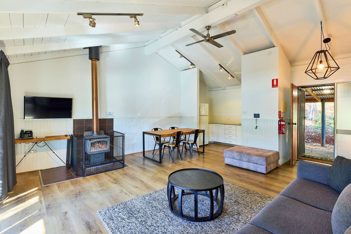 A spacious living area with a fireplace, a dining table, and a comfortable seating area.