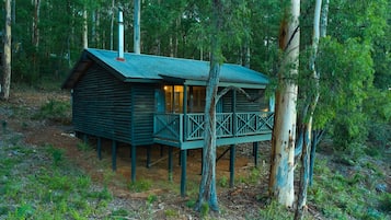 Eine Holzhütte mit Balkon, umgeben von Bäumen.