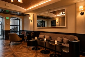 A modern interior with a wooden floor, a sofa, a table, and a mirror. - Hollywood Hotel (Los Angeles)