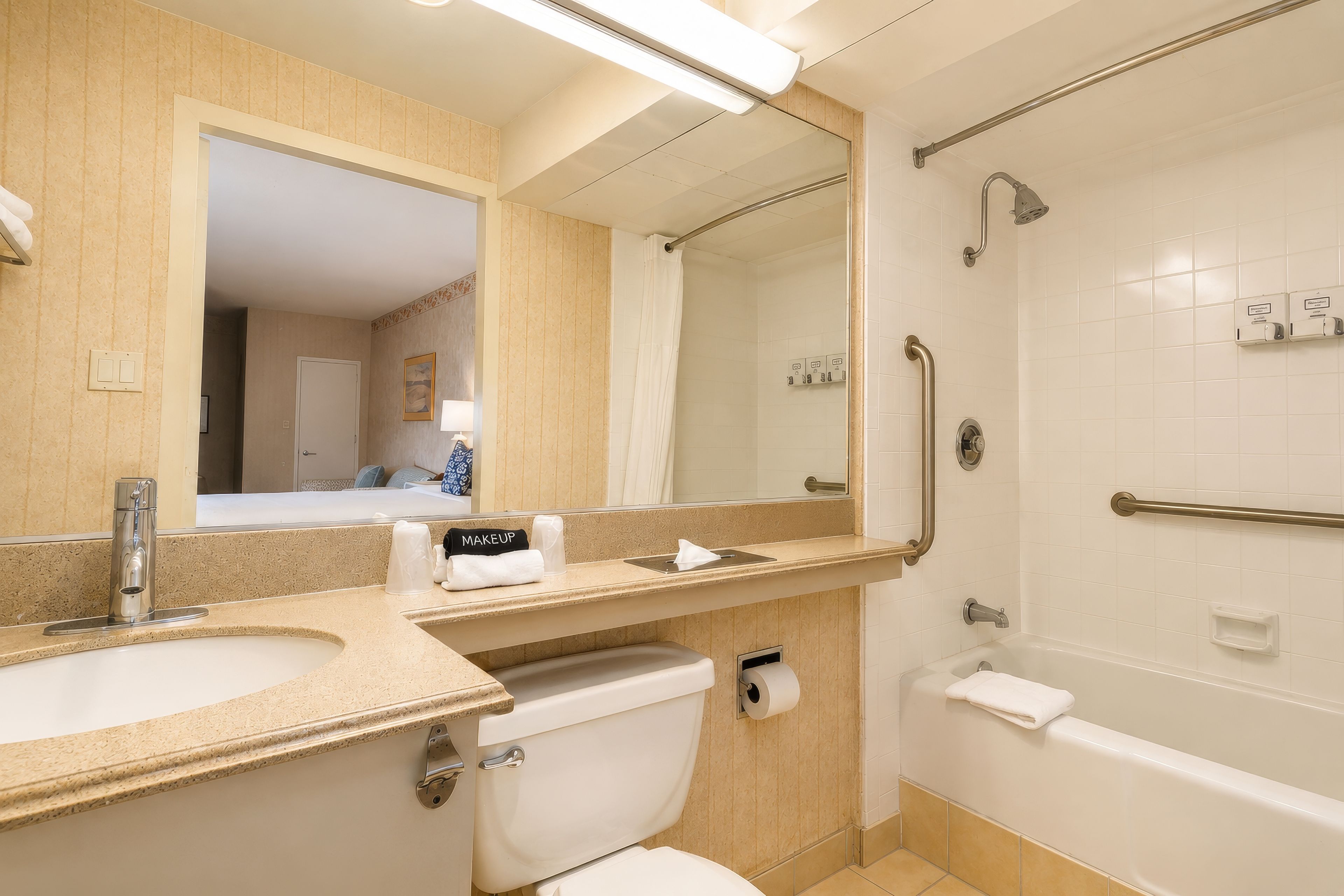 Ein Badezimmer mit Waschbecken, Spiegel, Toilette und Dusche.