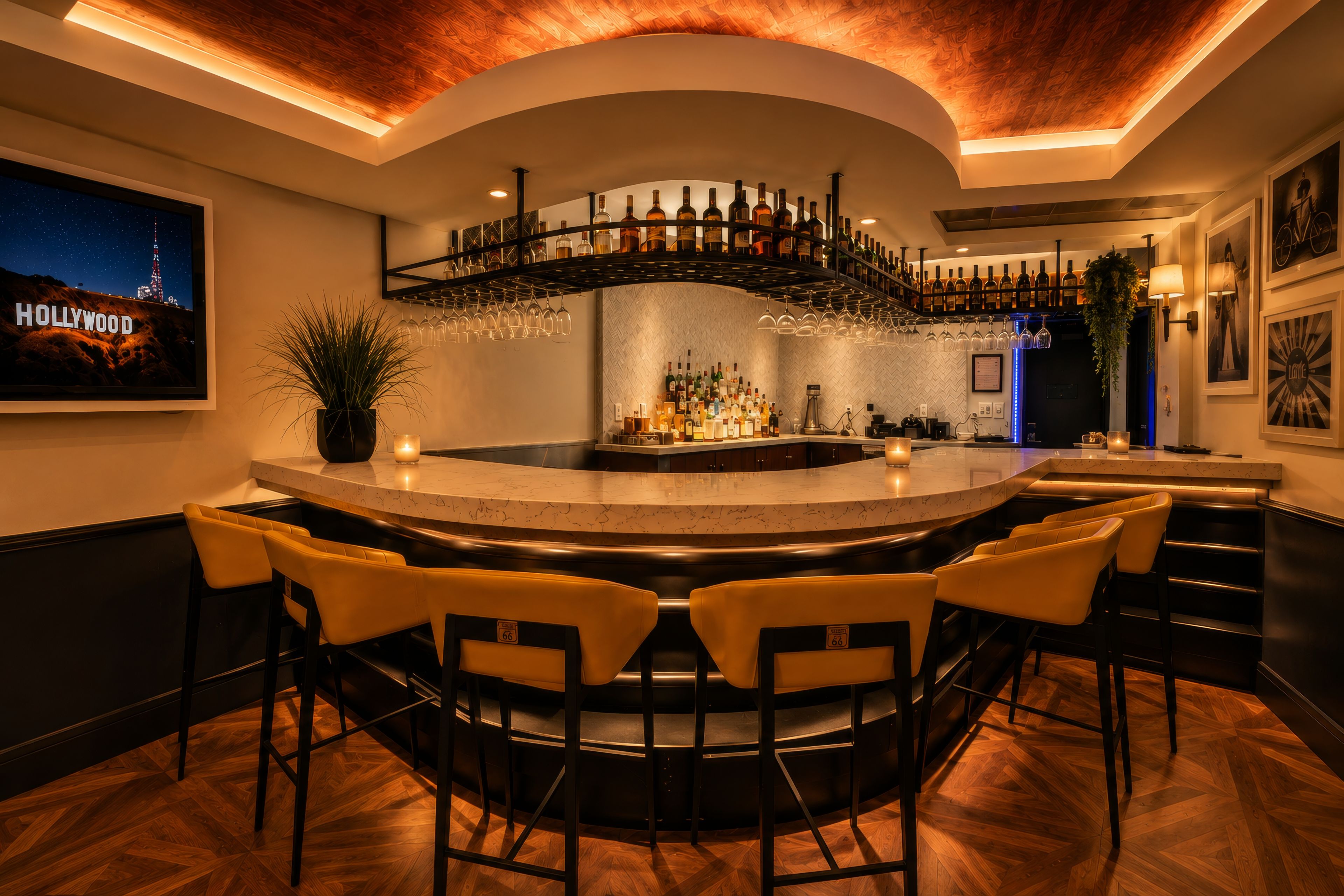A bar area with a curved counter, multiple seating options, and a variety of bottles and glasses displayed.