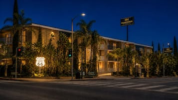 Un hotel con un cartel que indica Hollywood Route 66, una intersección y un semáforo.