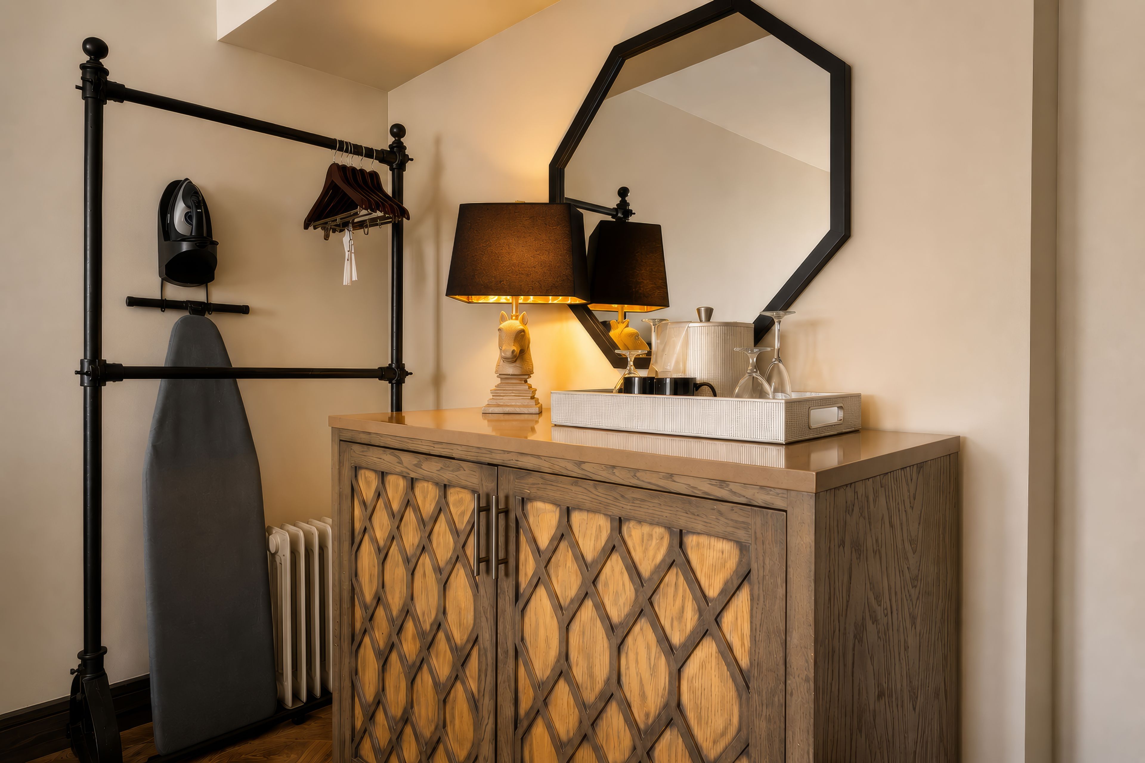Une pièce avec un radiateur, un miroir, une lampe et un meuble.