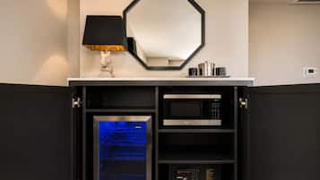 A kitchen with a built-in oven, microwave, and a digital clock on the wall.