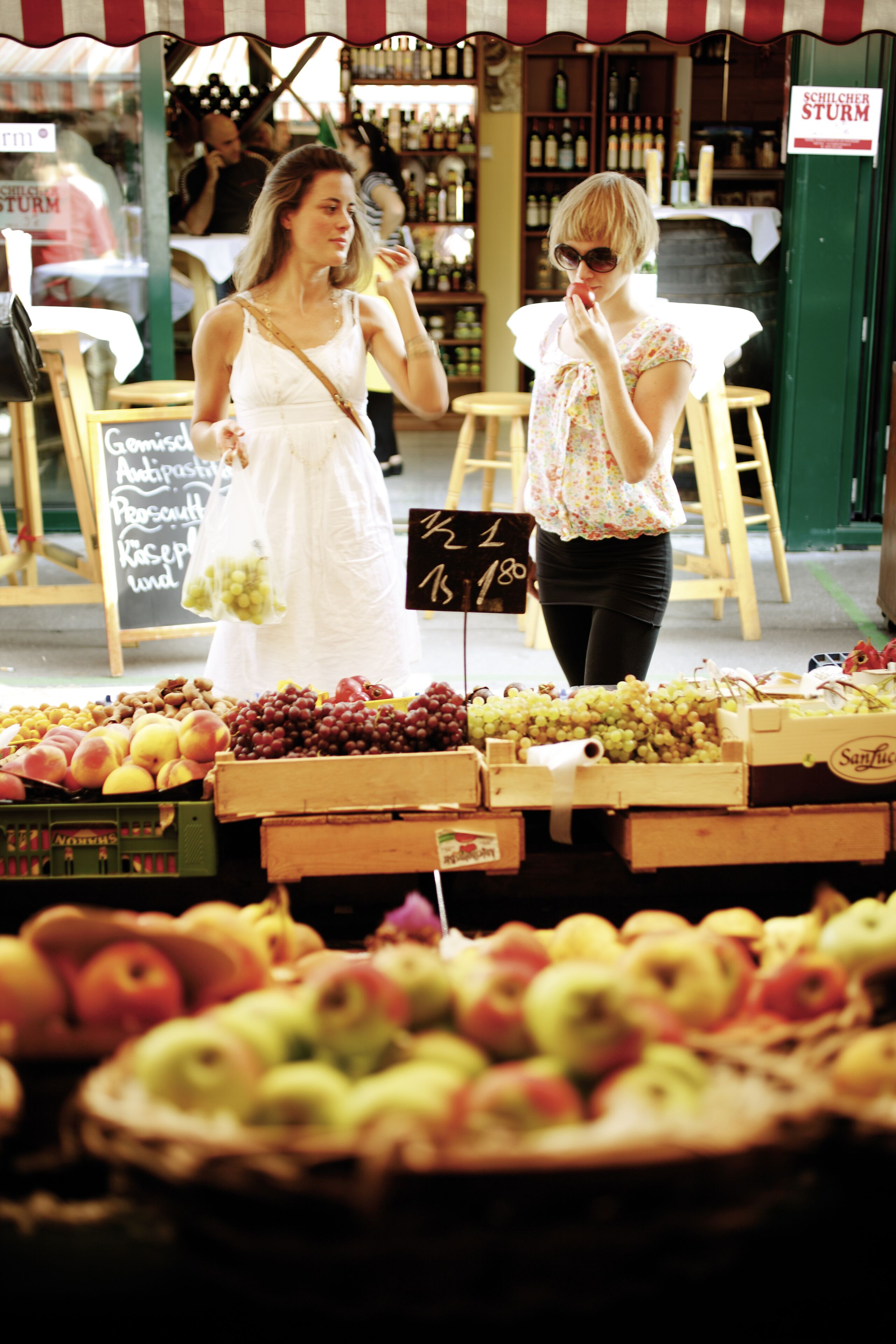 A fruit stand with various fruits and a sign indicating prices.