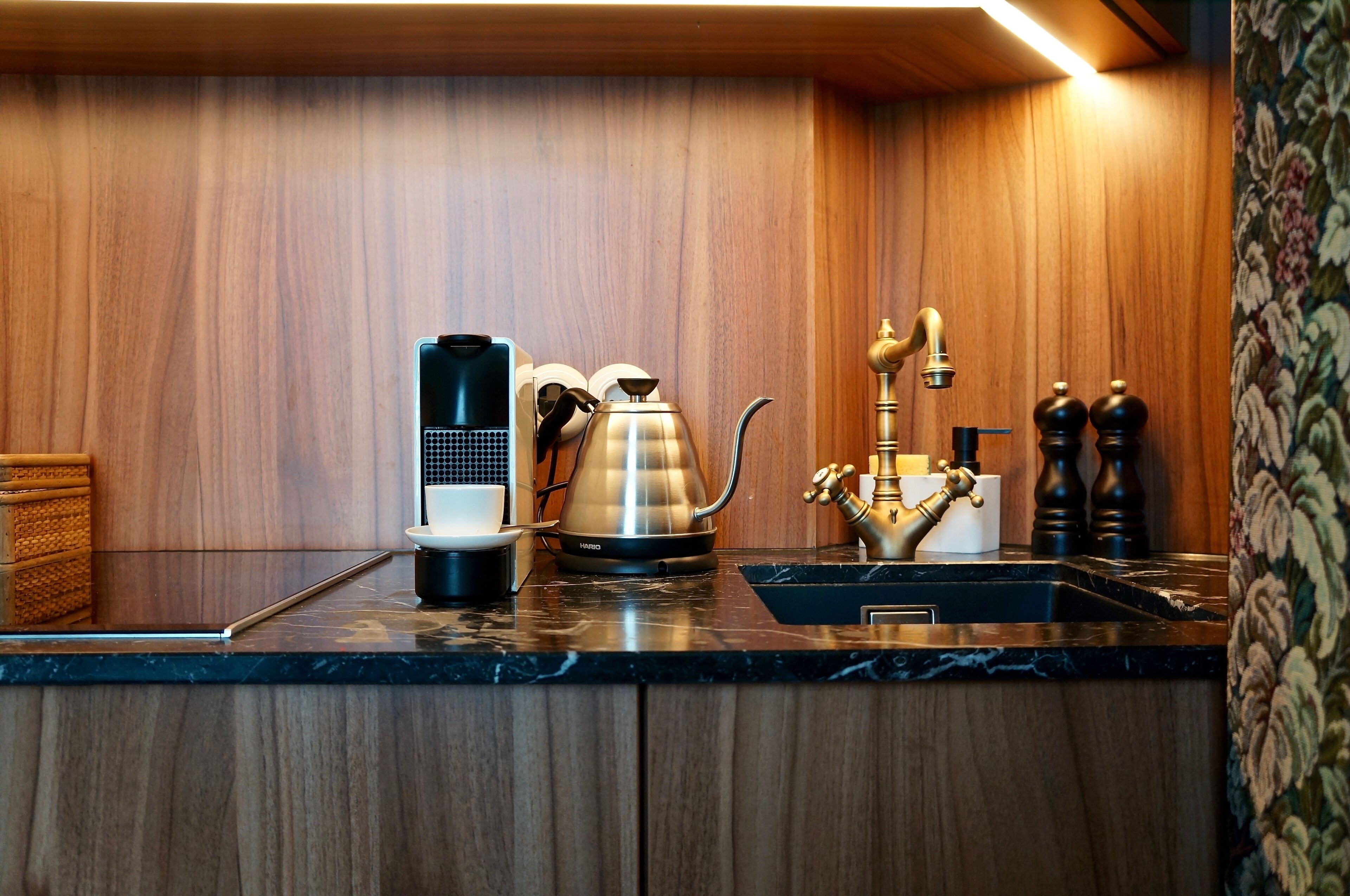 Eine Küche mit Kaffeemaschine, Wasserkocher und Spüle.