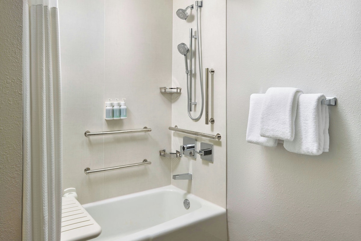 Une salle de bain avec une baignoire, une douche et un porte-serviettes.