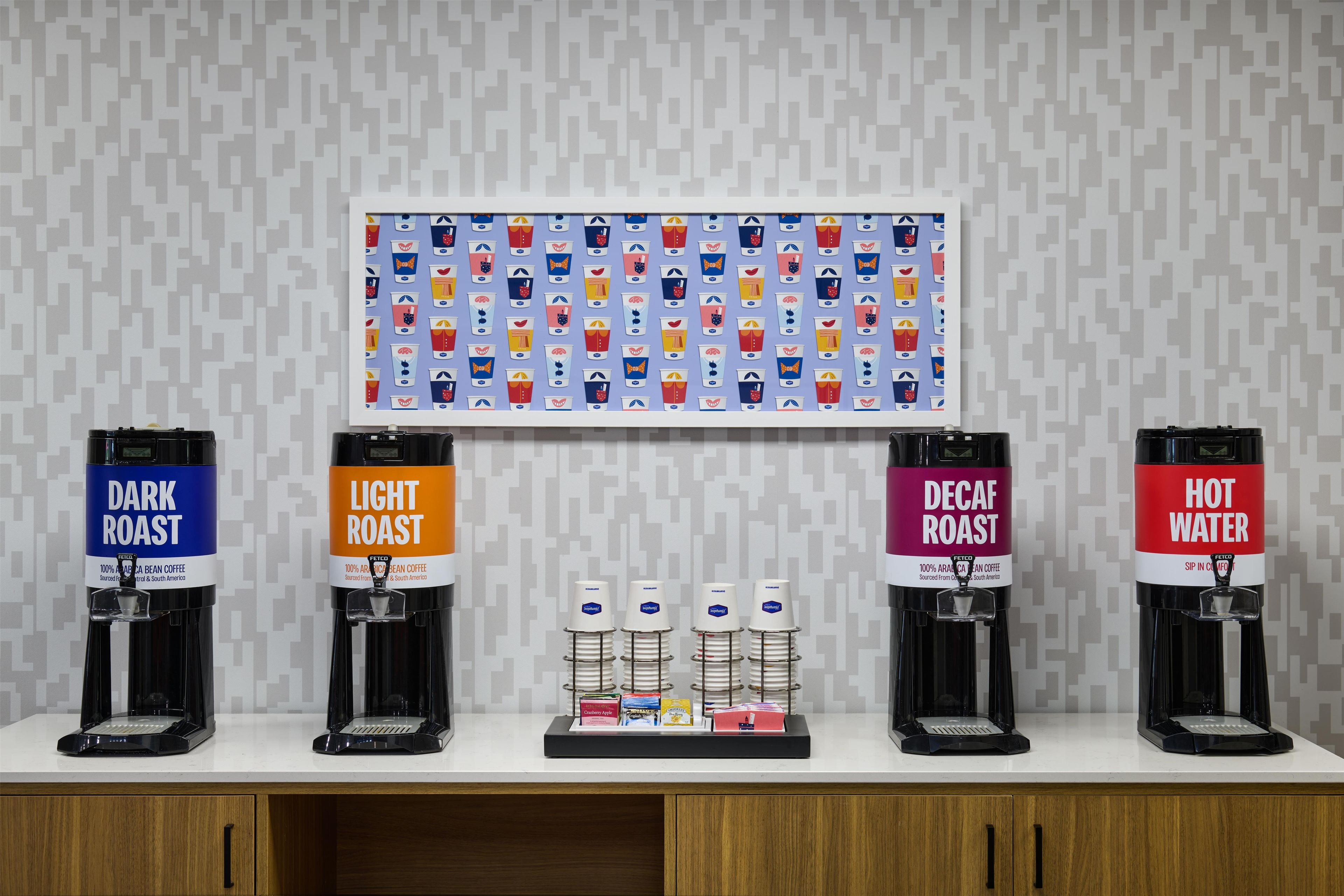 A coffee station with four coffee dispensers labeled 'Dark Roast,' 'Light Roast,' 'Decaf Roast,' and 'Hot Water.'