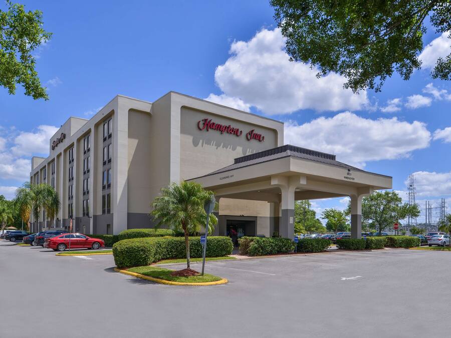 Ein Hampton Inn Hotel mit blauem Himmel und Autos auf dem Parkplatz.