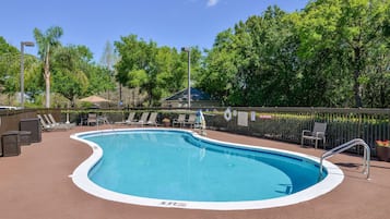 Una piscina al aire libre, sombrillas, sillones reclinables de piscina