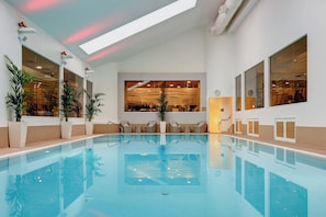 Relax by the serene pool surrounded by lush greenery and natural light.