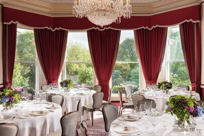 Formal dining room with round tables, fine china, and comfortable seating.