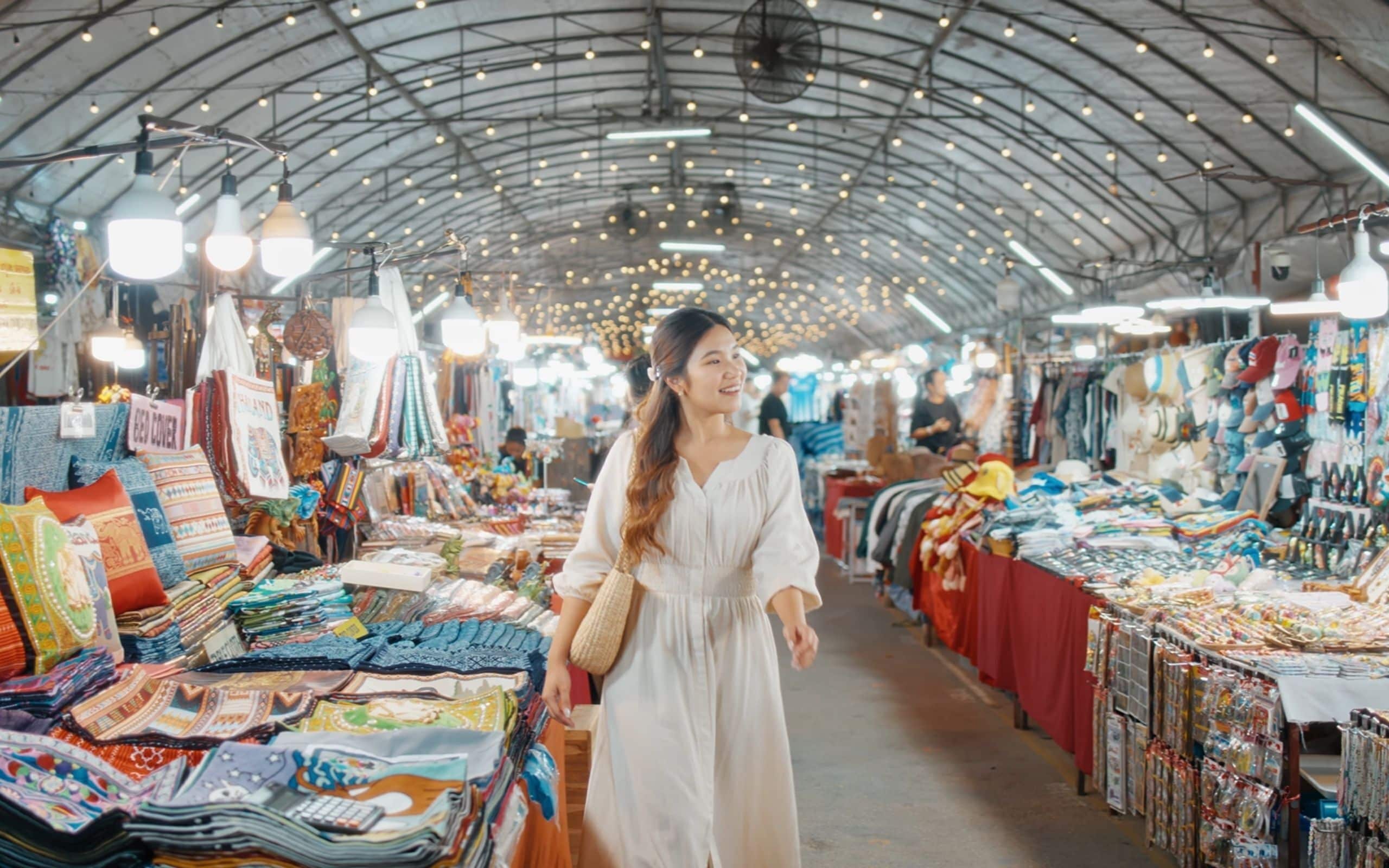 A market with various stalls selling textiles and clothing.
