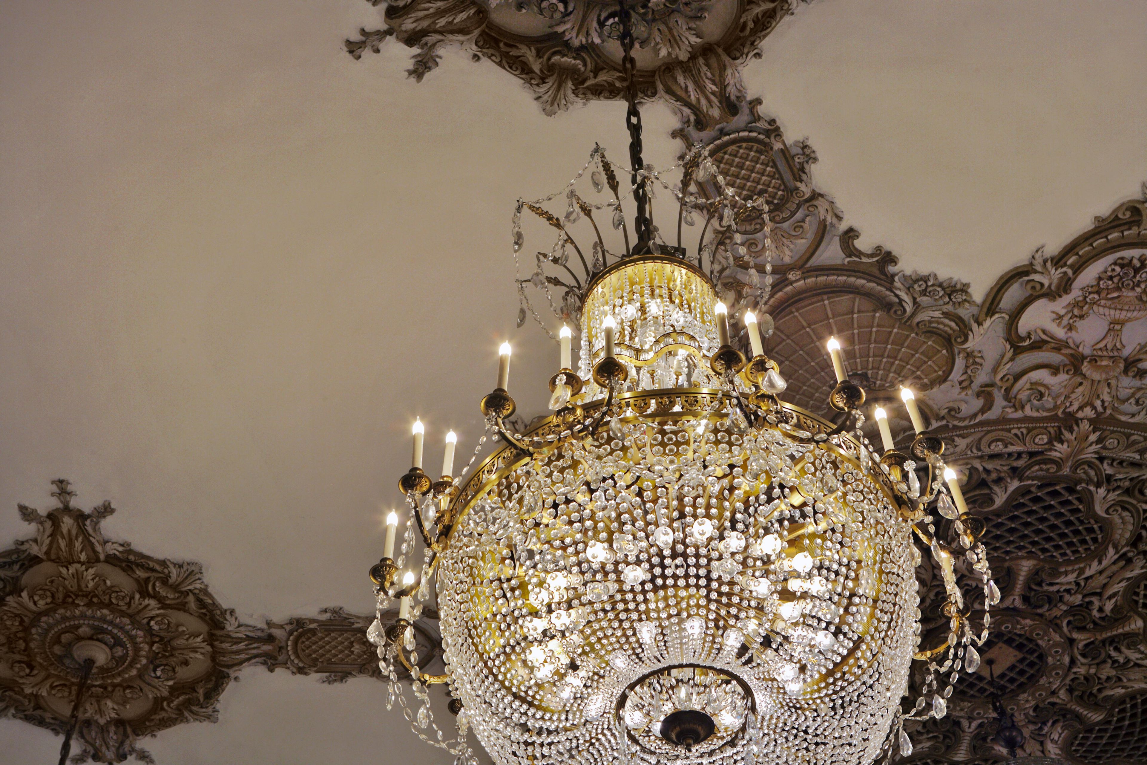 An ornate chandelier with multiple candles and crystal decorations.