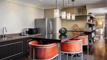 A modern kitchen with a central island, stainless steel appliances, and pendant lighting.