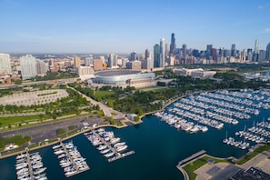 A marina with numerous boats docked, surrounded by a cityscape with high-rise buildings and a stadium. - Hilton Chicago (Chicago)