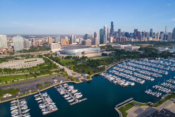 A marina with numerous boats docked, surrounded by a cityscape with high-rise buildings and a stadium. - Hilton Chicago (Chicago)
