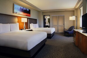 A hotel room with two beds, a desk with a television, a chair, a desk lamp, and a painting on the wall. - Hilton Chicago (Chicago)
