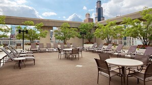 A rooftop lounge with outdoor seating and a view of the city skyline. - Hilton Chicago (Chicago)