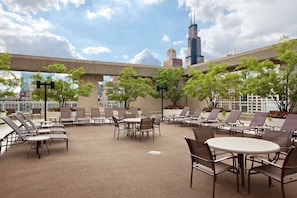 A rooftop lounge with outdoor seating and a view of the city skyline. - Hilton Chicago (Chicago)