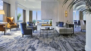 A spacious hotel lobby with a large seating area, a flat-screen TV, and a view of the ocean. - Hilton Chicago (Chicago)