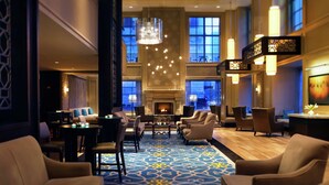 A spacious lobby with a patterned carpet, comfortable seating, a fireplace, and large windows. - Hilton Chicago (Chicago)