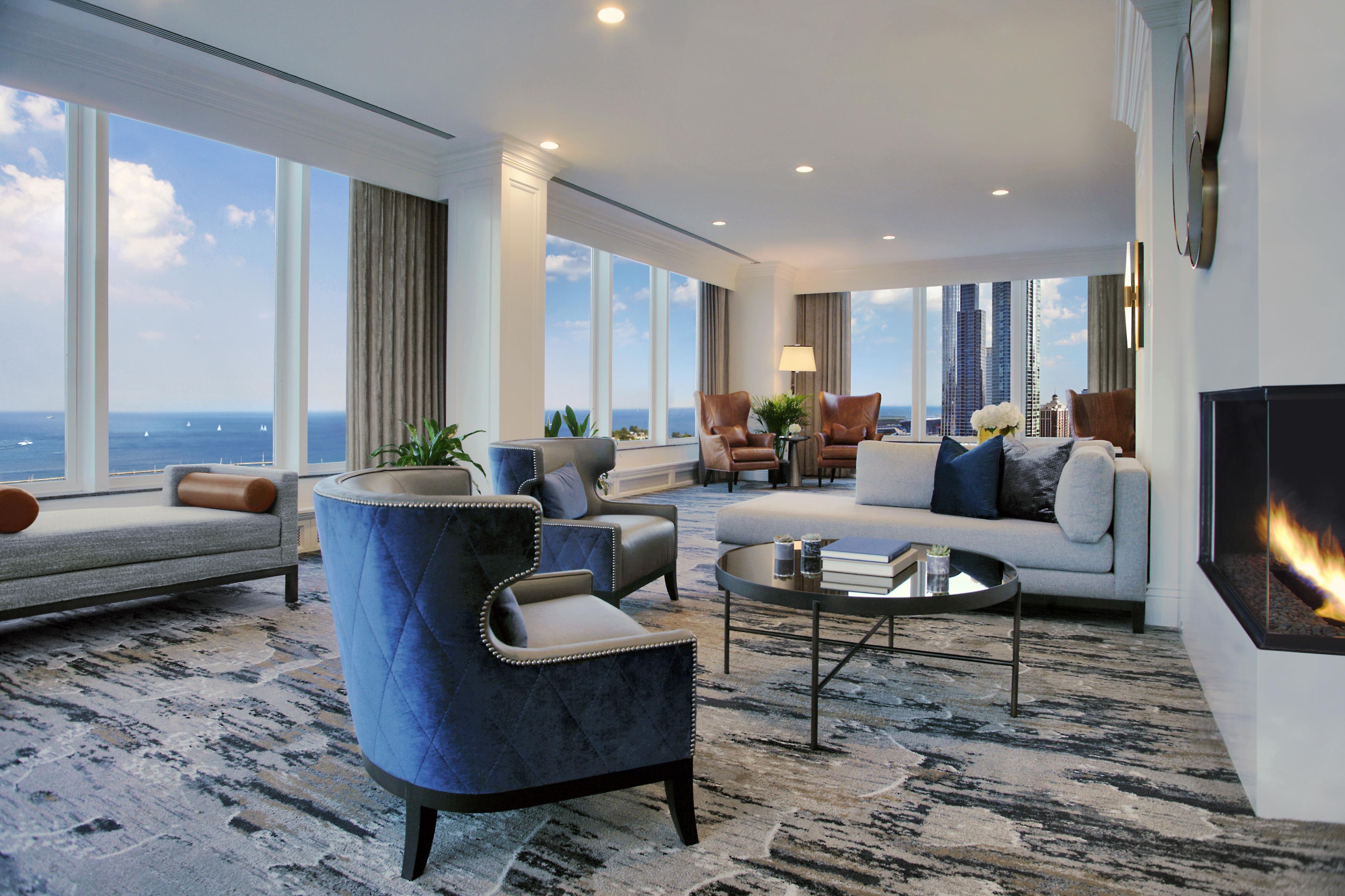 A spacious living room with a large window offering a city view, a fireplace, and modern furniture.
