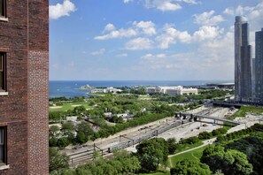 Located in an urban setting, this high-rise building offers stunning views of a waterfront and a park area with lush greenery.